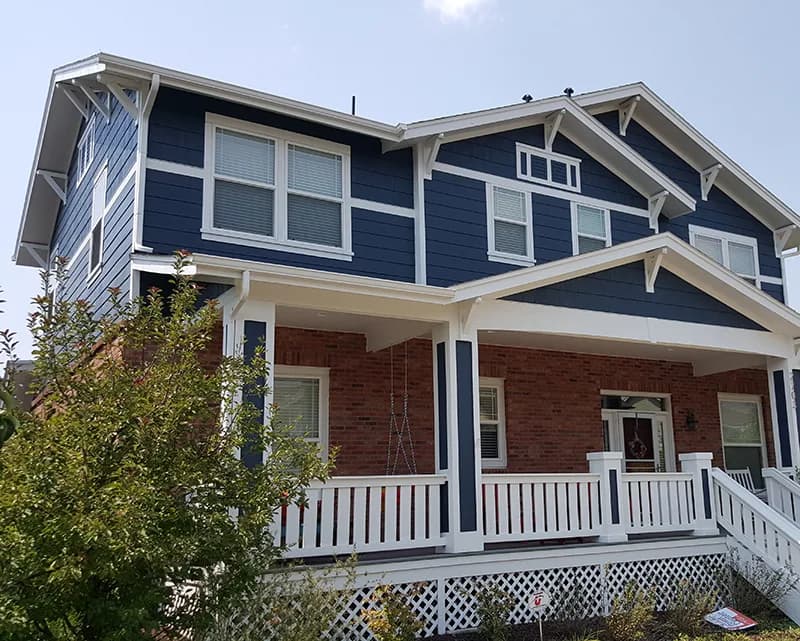 Blue craftsman house with fresh white trim, painted by Colorado Quality Painting