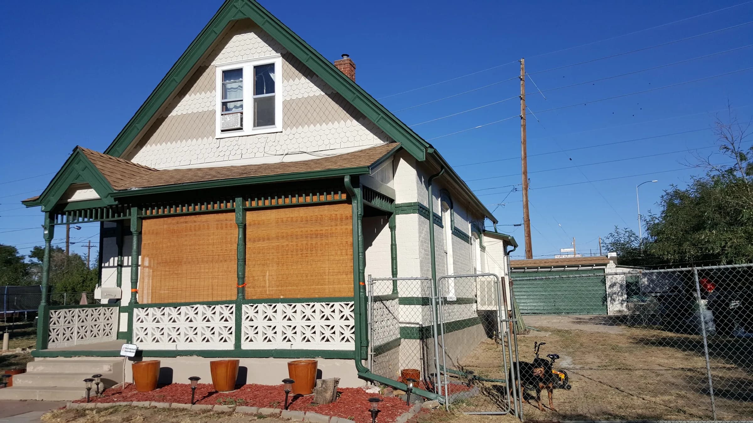 Cream Victorian bungalow with green trim, a classic Denver house, freshly painted