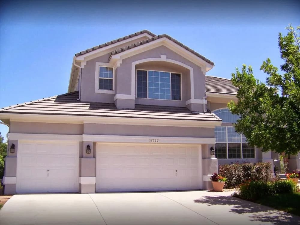 Tan Mediterranean stucco house with a clay tile roof, repainted