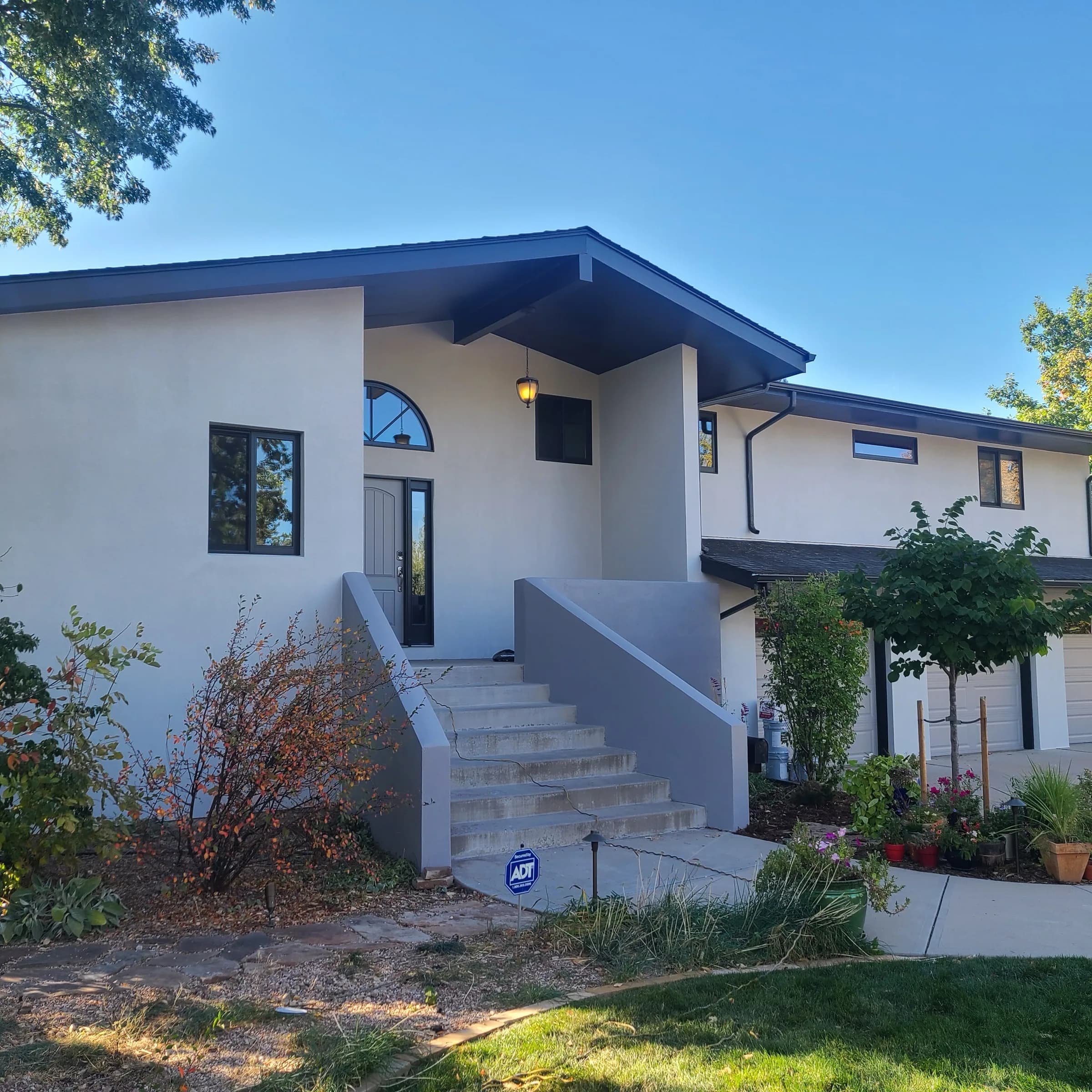 White stucco mid-century modern house with a low-pitch roof