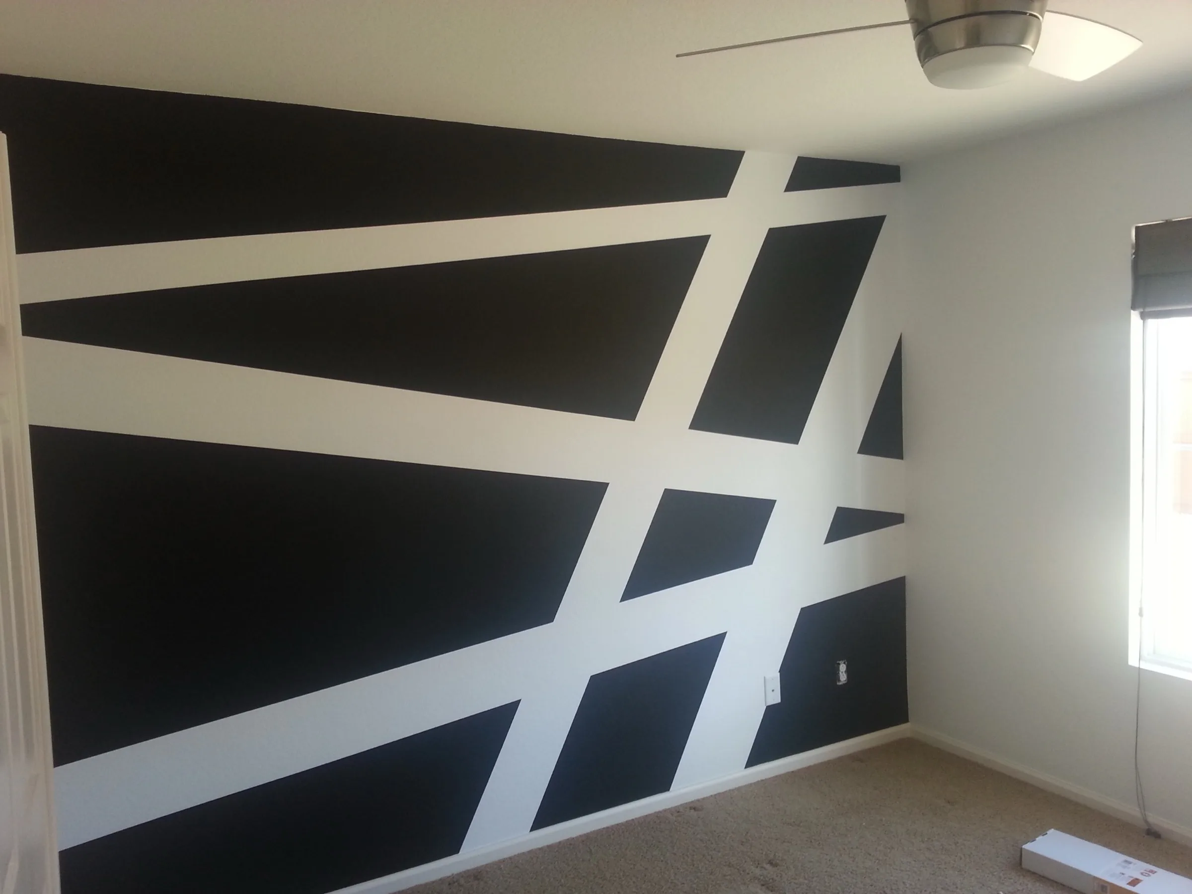 Bold black and white geometric accent wall in a bedroom