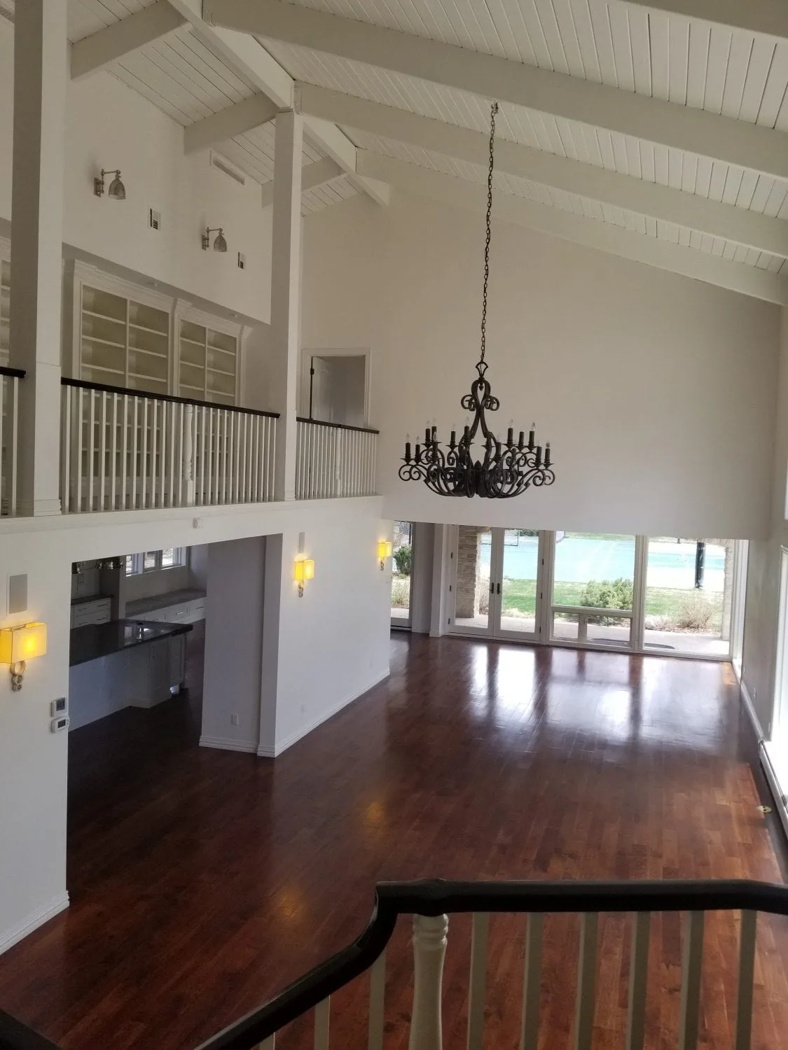 Vaulted loft living room with fresh paint, wood floors and a chandelier