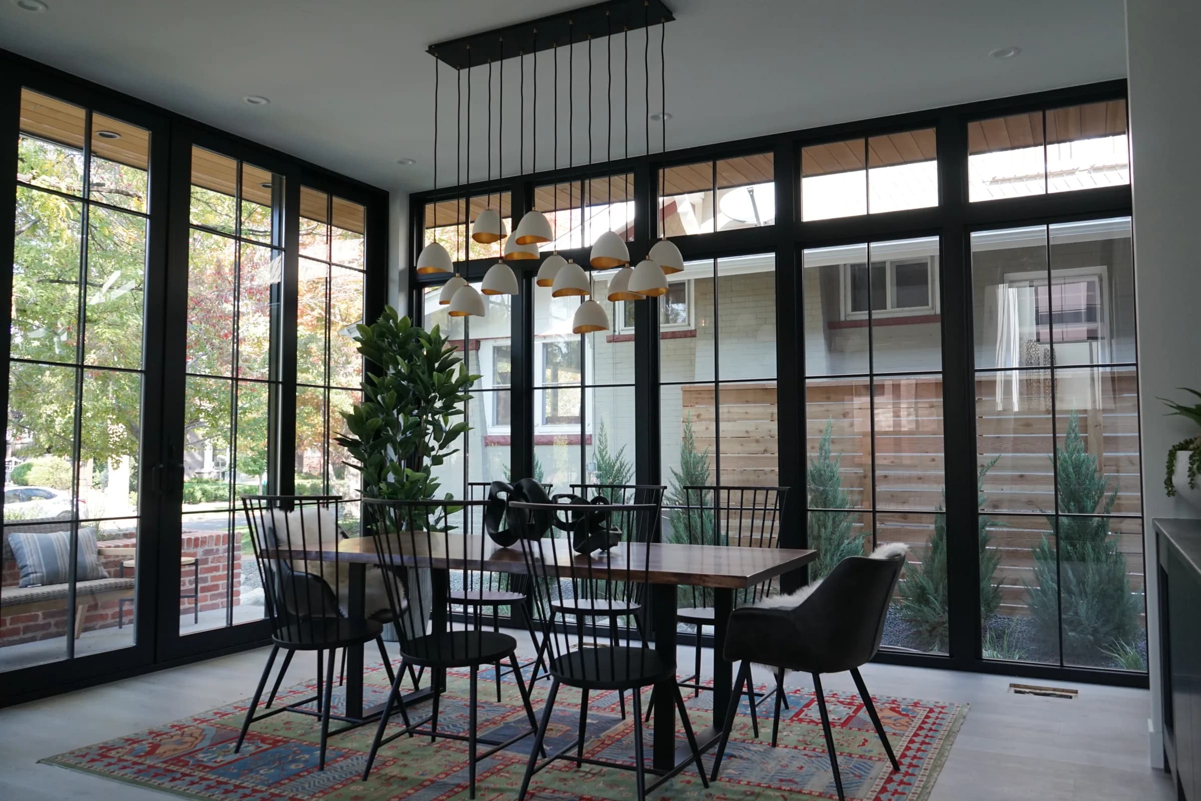 Dining area with floor-to-ceiling black-framed windows and clean white walls